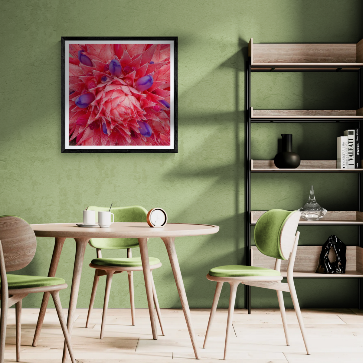 All at Once botanical art print with vivid pink and violet flowers in a black frame on a sunlit green dining room wall.
