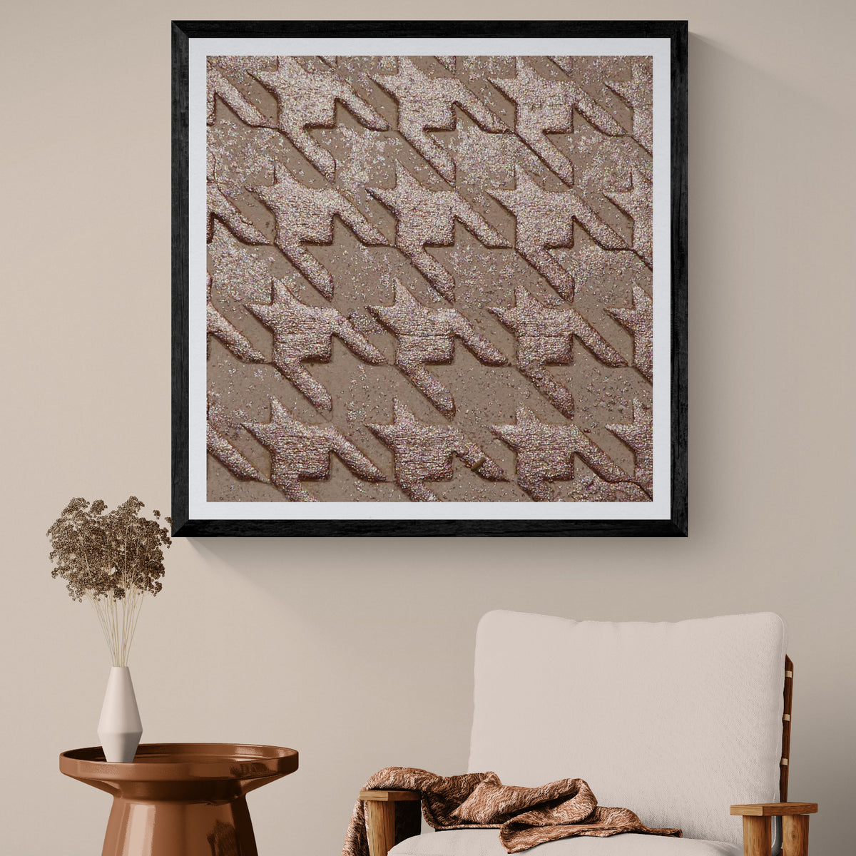 Glint Grid metallic houndstooth art print displayed as 30 × 30 wall art in a black frame above a neutral chair in a warm modern living room.