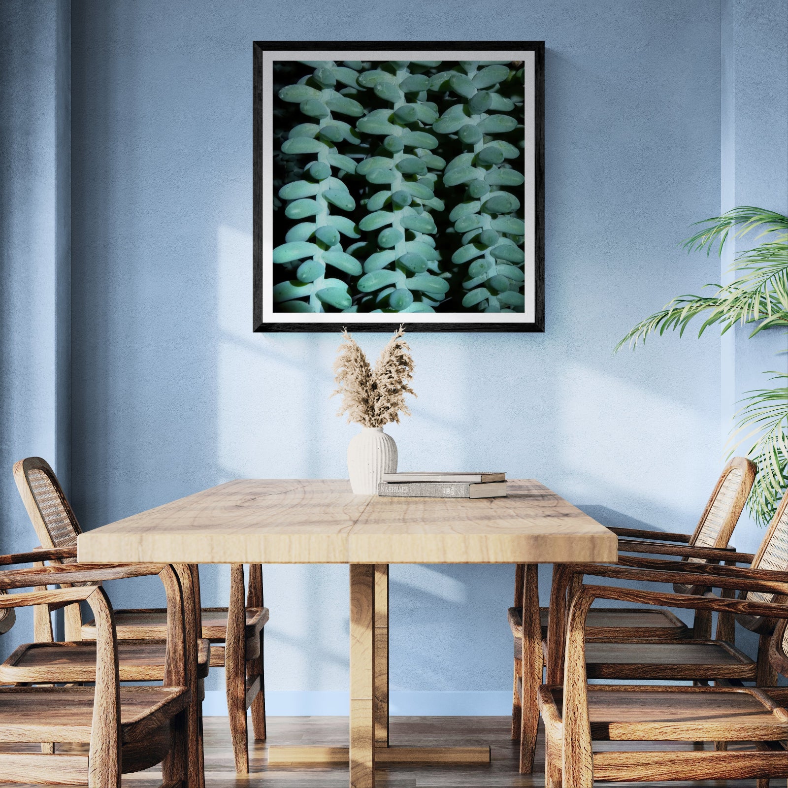 Good Company succulent photography art print displayed as 30 × 30 wall art in a black frame above a wooden dining table in a sunlit blue room.