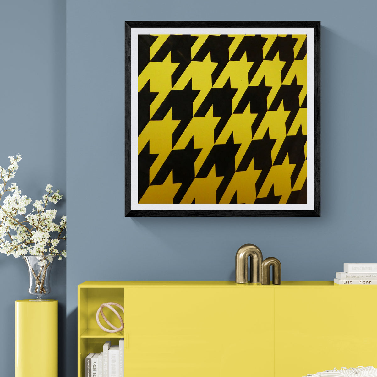 Haute Voltage yellow and black houndstooth art print displayed as 30 × 30 wall art in a black frame above a yellow cabinet on a blue wall.