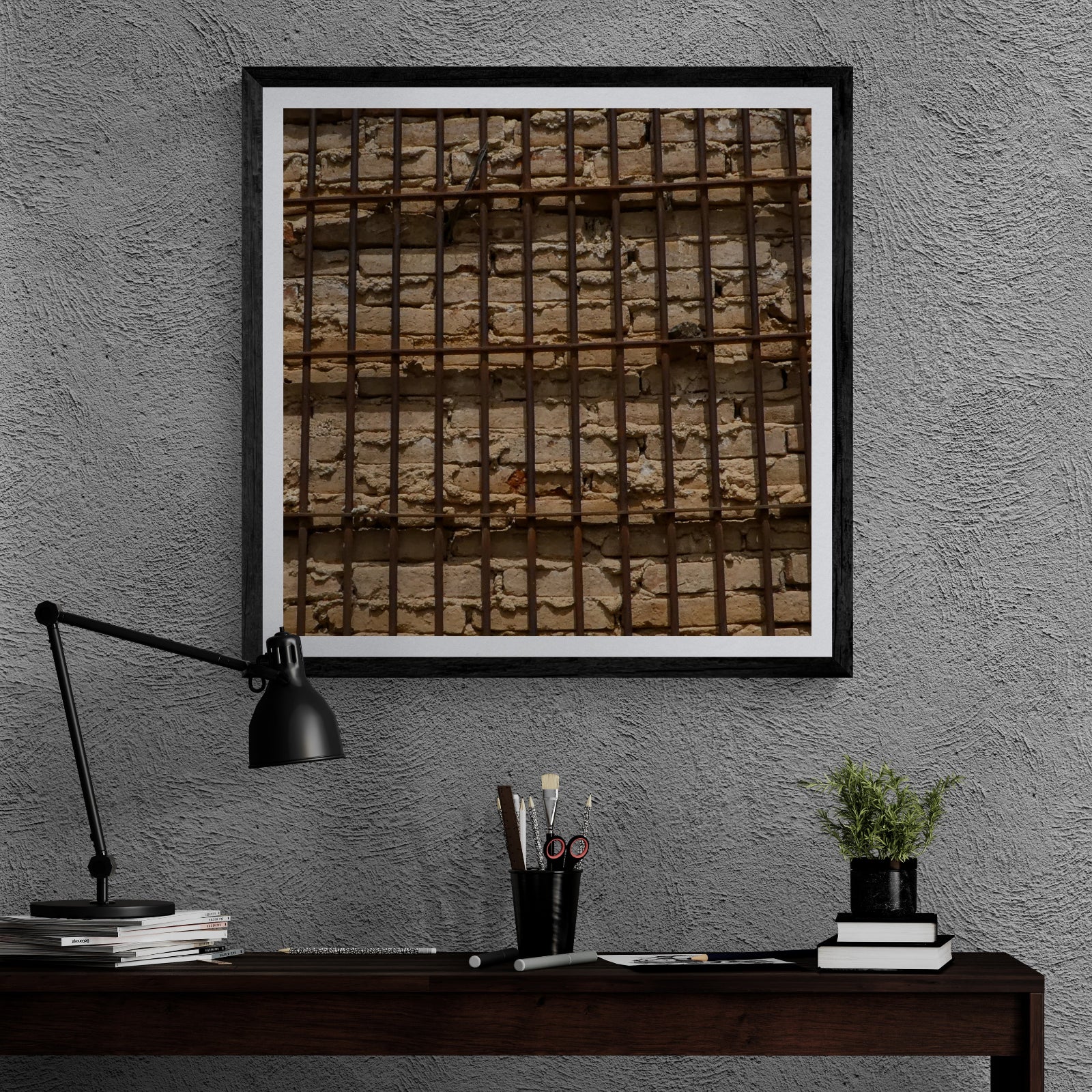 Holding Pattern rusted metal grid and weathered brick photography art print displayed as 30 × 30 wall art in a black frame above a dark wood desk.