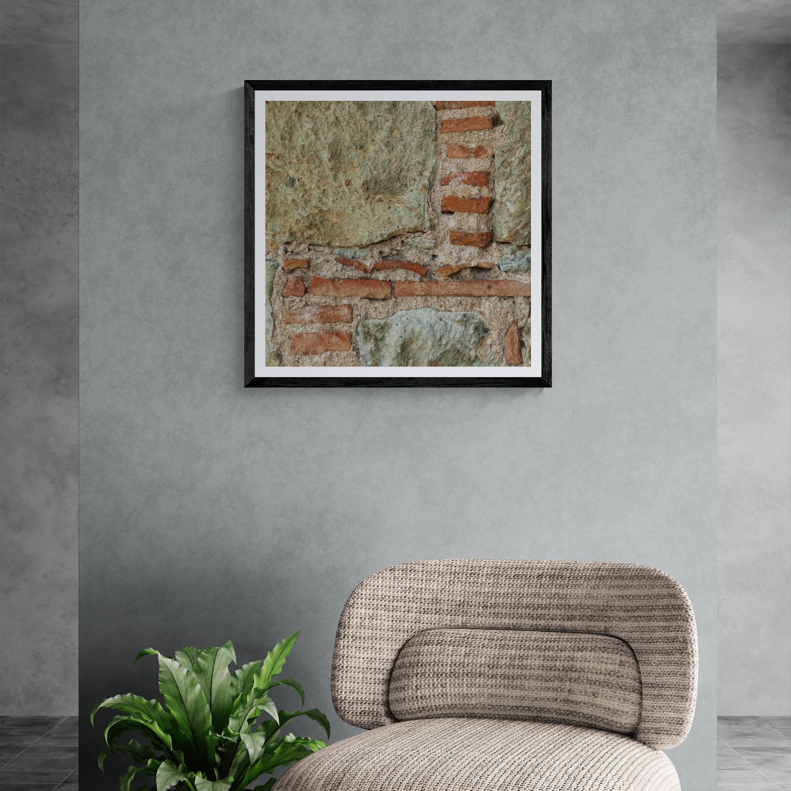 Patchwork Geometry weathered brick and plaster photography art print displayed as 30 × 30 wall art in a black frame above a modern chair.
