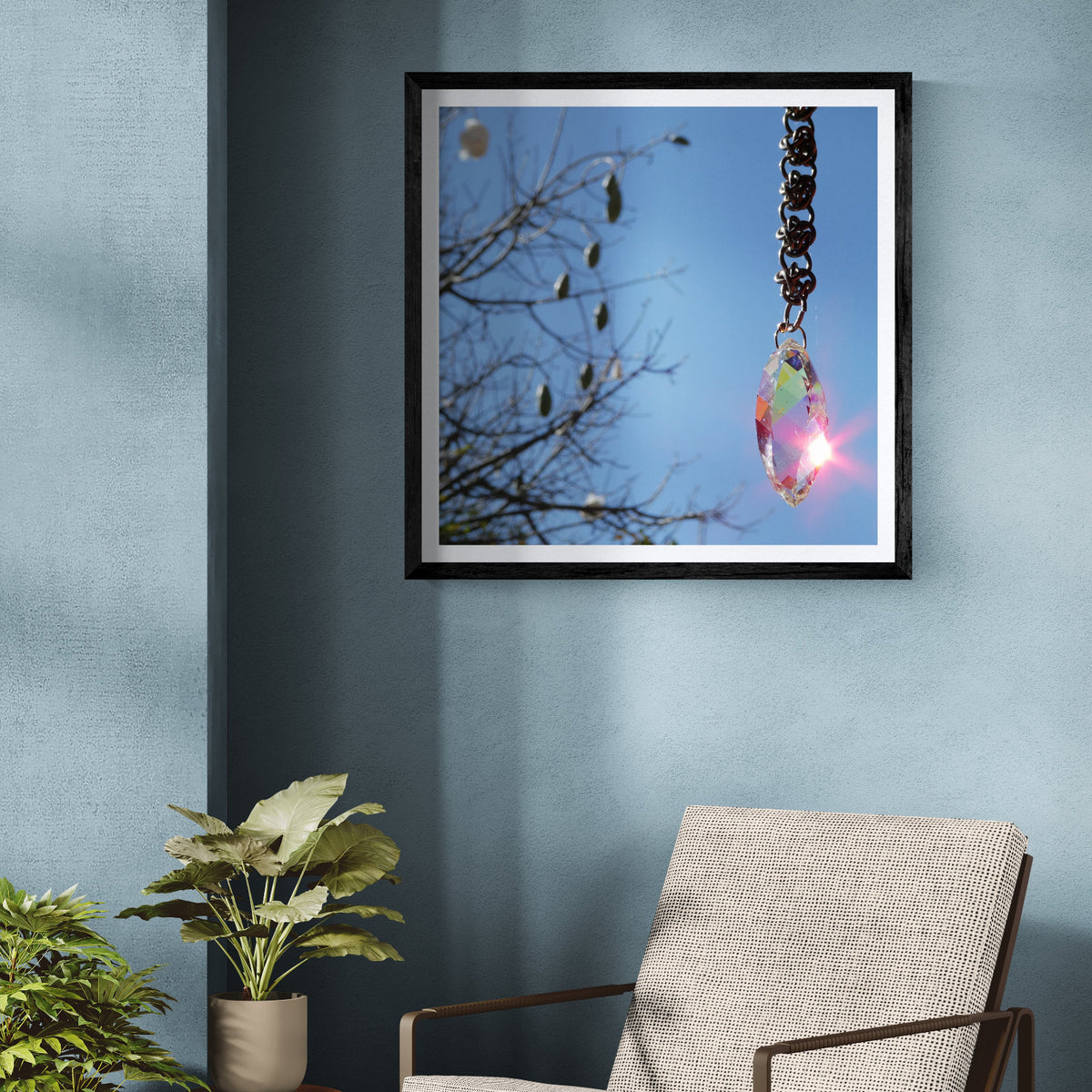 Pochote Prism crystal and sunlight photography art print displayed as 30 × 30 wall art in a black frame on a blue wall beside indoor plants.