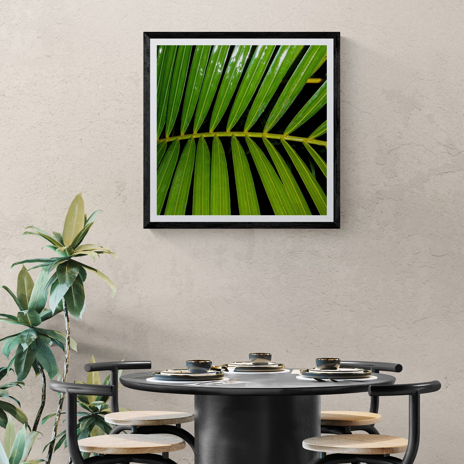 Side Effects green palm frond photography art print displayed as 30 × 30 wall art in a black frame above a modern dining table.